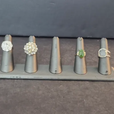 Collection of four vintage and contemporary fashion rings, including rhinestone clusters, a green jade cabochon, and a David Yurman-style...
