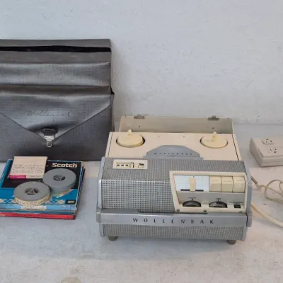 Vintage Wollensak reel-to-reel tape recorder with its original carrying case and several pre-recorded tapes tapes, circa 1950s.