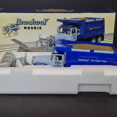 First Gear 1/34 scale Brockway Huskie dump truck with snow plow, featuring a blue and white 'Huskie Hauling' livery, in its...