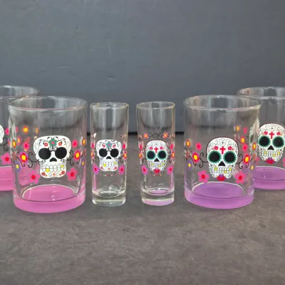 Six-piece Dia de los Muertos glassware set, including four lowball glasses and two tall shot glasses, featuring sugar skull and floral...