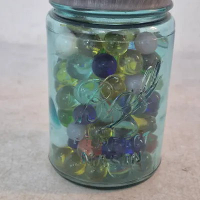 Vintage blue glass Ball Perfect Mason jar filled with an assortment of colorful glass marbles (some are magnesium, turn orange under a...