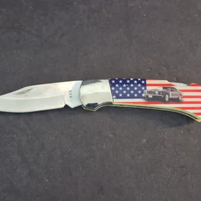 Single-blade folding pocket knife featuring an American flag and classic 1969 Ford Mustang graphic on the handle.