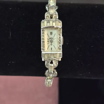 Vintage Mido ladies' cocktail watch featuring a rectangular face accented with rhinestones on a silver-tone link band.