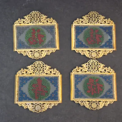 Set of four vintage Chinese brass and enamel plaques, featuring ornate openwork borders and central medallions with red Chinese...