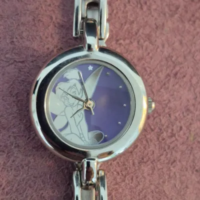 Disney Tinker Bell silver-tone ladies' watch featuring a purple dial with Tinker Bell illustration and a link bracelet.