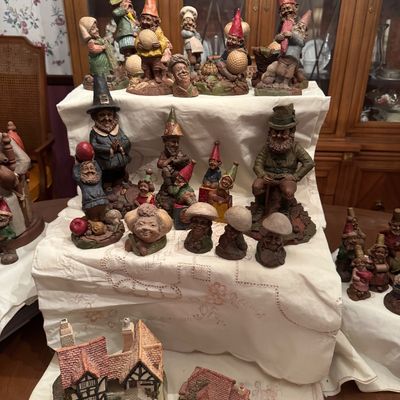 Sale Photo Thumbnail #53: Collection of vintage Tom Clark gnome figurines and miniature resin cottage houses displayed on tiered shelving.