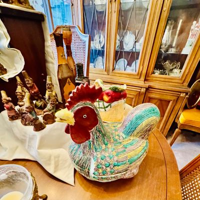 Sale Photo Thumbnail #23: Vintage ceramic rooster tureen with colorful hand-painted feathers, displayed alongside a collection of small gnome figurines and an apple-themed ceramic basket.