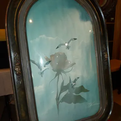 Sale Photo Thumbnail #38: Vintage framed print featuring a single rose and seagulls against a blue sky, housed in an ornate, dark-finished oval frame with convex glass.