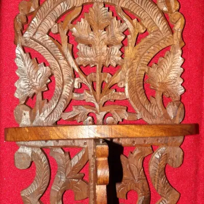 Sale Photo Thumbnail #17: Hand-carved wooden wall shelf featuring intricate openwork floral and leaf motifs, likely of Indian or East Asian origin.