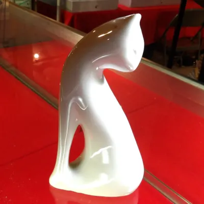 Sale Photo Thumbnail #23: Royal Copenhagen mid-century modern white porcelain cat figurine, designed by Jeanne Grut, featuring a sleek, stylized silhouette with a glossy glaze.