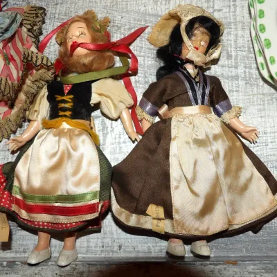 Sale Photo Thumbnail #52: Two vintage mid-century plastic dolls dressed in traditional European folk costumes, featuring a blonde doll labeled "Tirol" and a dark-haired doll labeled "Fra. Brita."