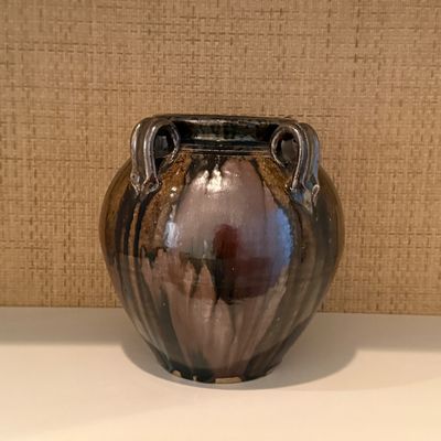 Hand-crafted studio pottery vessel featuring a glossy variegated dark brown glaze with applied side handles.