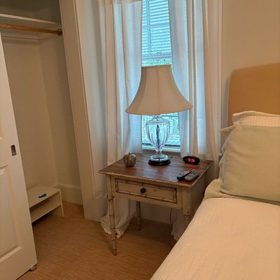 Rustic distressed nightstand with bamboo-style legs paired with a cut crystal table lamp.
