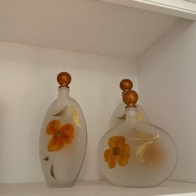 Sale Photo Thumbnail #112: Set of three vintage frosted glass perfume bottles decorated with hand-painted orange flowers and gold leaf accents.