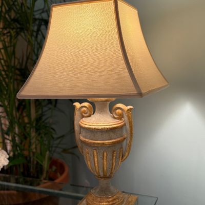 Neoclassical style urn-shaped table lamps featuring gilt accent details, a square pedestal base, and an illuminated pagoda fabric shade.