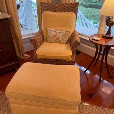 Woven seagrass armchair with yellow fabric seat cushions paired with a matching upholstered ottoman.