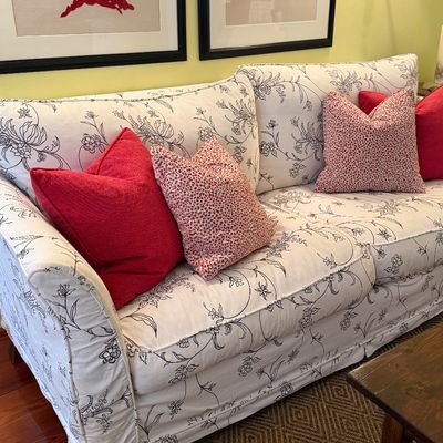 Upholstered sofa featuring a white fabric with black floral line art print, down filled 