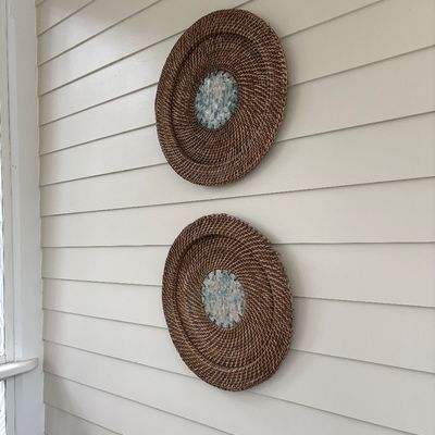 Pair of circular woven rattan wall decor plates featuring mosaic mother-of-pearl center accents.