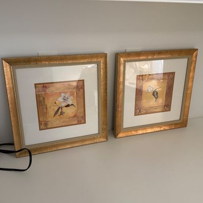 Pair of square framed floral botanical prints in textured gold-tone metallic frames with white matting.