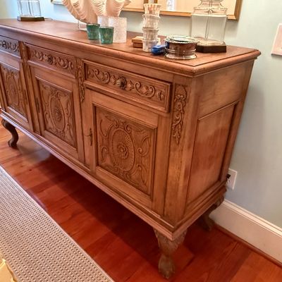 Sale Photo Thumbnail #109: French Provincial style carved wood sideboard buffet, featuring ornate floral paneling, cabriole feet, and three drawers over lower cabinets.
