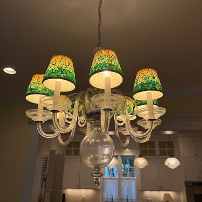 Multi-arm glass chandelier featuring yellow and green mosaic stained-glass mini shades and clear curved blown glass arms.