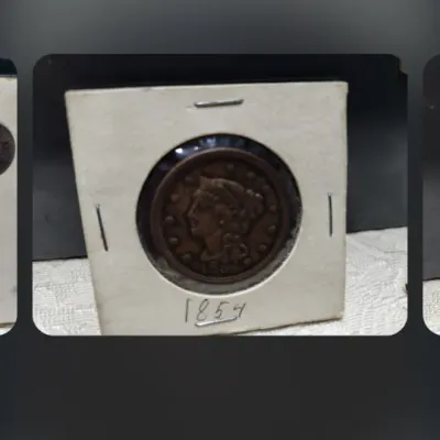 An 1854 United States Braided Hair large cent coin, housed in a cardboard 2x2 coin holder.