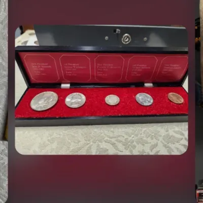 Five-piece US presidential coin set displayed in a black presentation box with a red velvet-lined interior.
