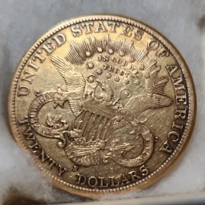 United States twenty-dollar gold coin, showing the reverse side with the heraldic eagle design and "In God We Trust" motto.