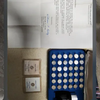 The Franklin Mint sterling silver Presidential Mini-Coin collection, featuring a blue display case, individual coin sleeves, and an...