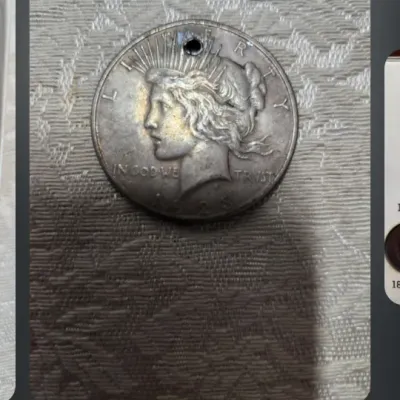 United States Peace silver dollar, dated 1923, featuring a hole drilled near the top edge for use as a pendant.