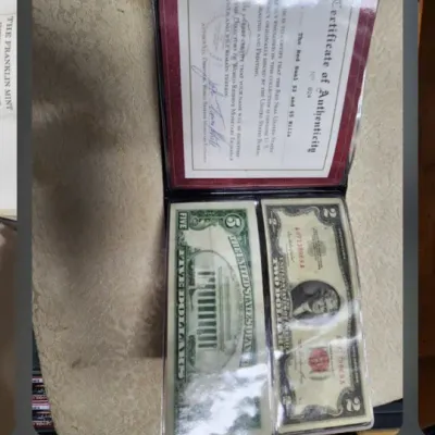 Screenshot of a mobile phone displaying a photo of a United States Red Seal $2 and $5 bill set, complete with a Certificate of...