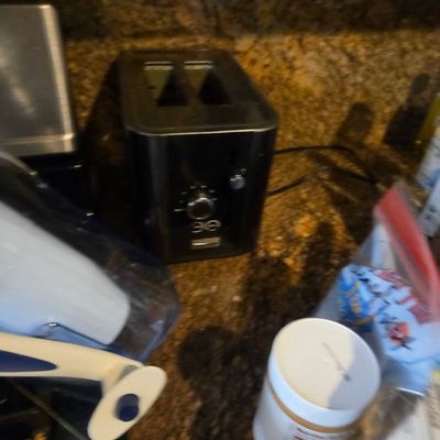 Sale Photo Thumbnail #21: Modern black two-slice toaster sitting on a granite countertop alongside various kitchen items.