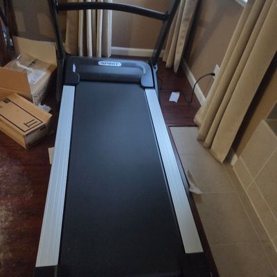 Sale Photo Thumbnail #2: Spirit motorized treadmill with a black belt and silver side rails, shown in a home setting.