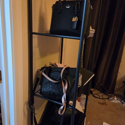 Sale Photo Thumbnail #27: Kate Spade black pebbled leather satchel and other black designer handbags displayed on a black metal shelving unit.