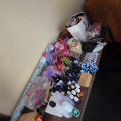 Sale Photo Thumbnail #40: Assorted craft supplies, wrapping paper, and small bottles arranged on a wooden table.