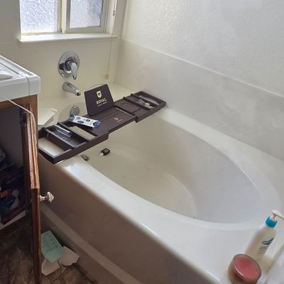 Sale Photo Thumbnail #53: Royal Craft Wood expandable bamboo bathtub caddy tray in a dark brown finish, shown resting on a white soaking tub.