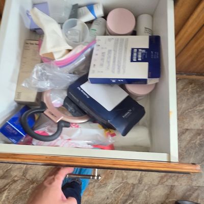 Sale Photo Thumbnail #56: An open wooden drawer containing an assortment of personal care items, cosmetics, and packaged goods.