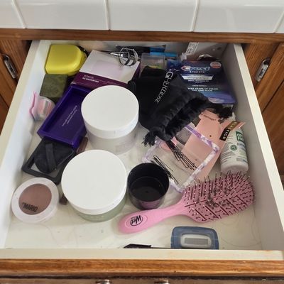 Sale Photo Thumbnail #55: Assorted personal care and beauty items in a bathroom drawer, including a pink Wet Brush, cosmetic jars, bobby pins, and teeth whitening strips.