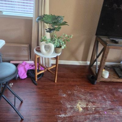 Sale Photo Thumbnail #49: Small round side table with a white top and wooden legs, holding artificial potted plants and a decorative white ceramic vase.