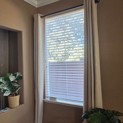 Sale Photo Thumbnail #43: Pair of beige grommet-top curtain panels with subtle metallic thread detailing, shown hanging on a dark metal rod.
