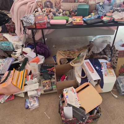 Sale Photo Thumbnail #61: A cluttered assortment of household goods, including tote bags, gift boxes, books, and small decorative items, arranged on and around a folding table.