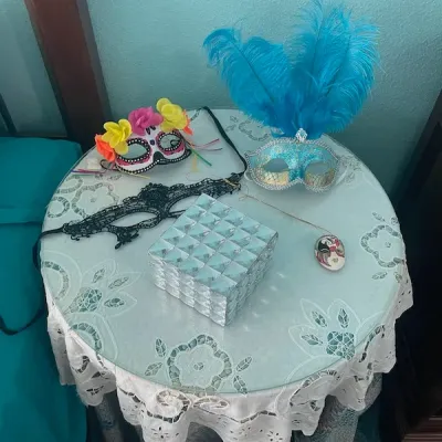 Collection of masquerade masks, including a blue feathered mask and a floral sugar skull mask, alongside a mirrored jewelry box on a...