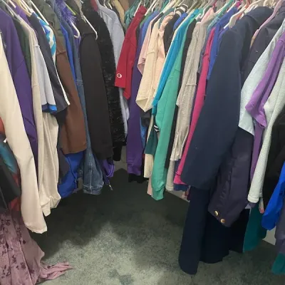 Walk-in closet packed with a variety of women's and unisex clothing hanging on wire shelving.