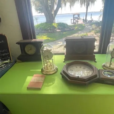 Collection of vintage table and mantle clocks, including a brass anniversary clock under a glass dome and an octagonal wall clock, on...