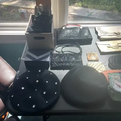 Collection of vintage women's accessories including black berets, evening clutches, beaded purses, and boxed gloves.