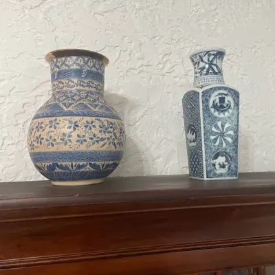 Two blue and white ceramic vases, including a rounded pottery vase with intricate floral and geometric patterns and a square-form...