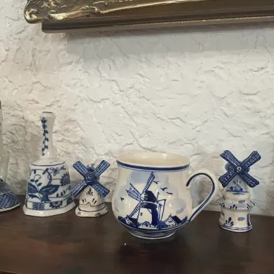 Collection of Delftware blue and white porcelain items, including a windmill ceramic mug, small windmill salt and pepper shakers, and a...