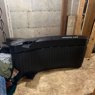 Sale Photo Thumbnail #52: Grit Runner curved manual treadmill base, stored on its side in a basement setting.