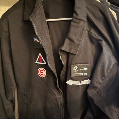 Sale Photo Thumbnail #21: Black zip-up mechanic-style jacket featuring a BMW Motorsport patch and various other automotive-themed patches on the front.