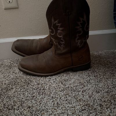 Sale Photo Thumbnail #24: Pair of Justin brown leather cowboy boots with decorative stitching on the shafts, showing light wear.